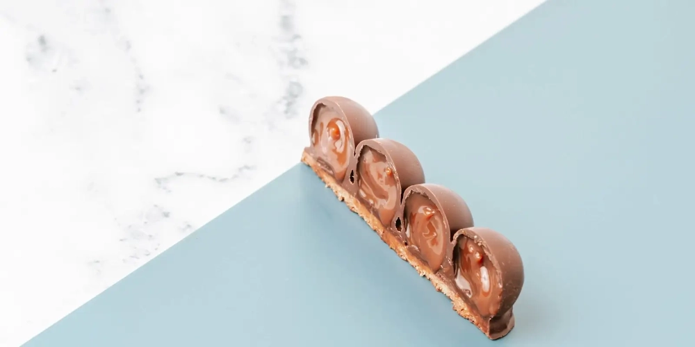 Czekoladowa pralina z nadzieniem na cienkim spodzie, oblewana czekoladą